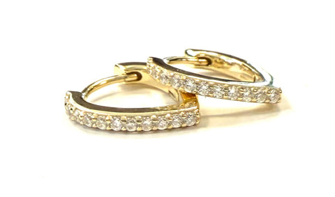 Vermeil over sterling silver oval huggie earrings with cubic zirconia stones.