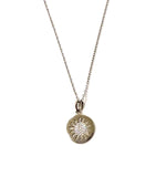 Sterling silver chain necklace with a gold disc pendant and a cubic zirconia starburst in the disc.