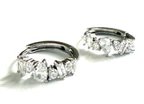 Sterling silver huggies with cubic zirconia staggered stones.