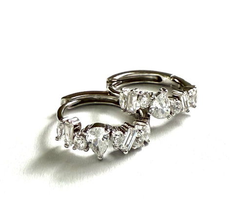 Sterling silver huggies with cubic zirconia staggered stones.